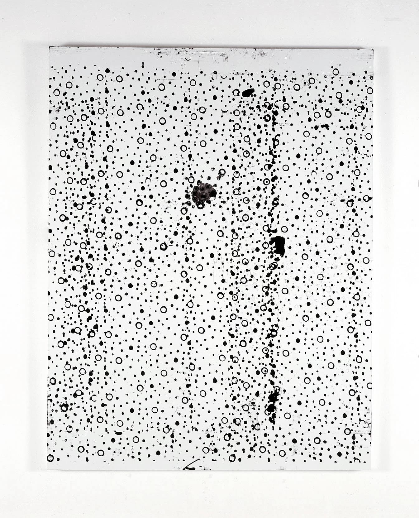 An image of a vertically oriented painting; the background is white and across the surface is a black pattern of dots and circles with irregularities and splotches.