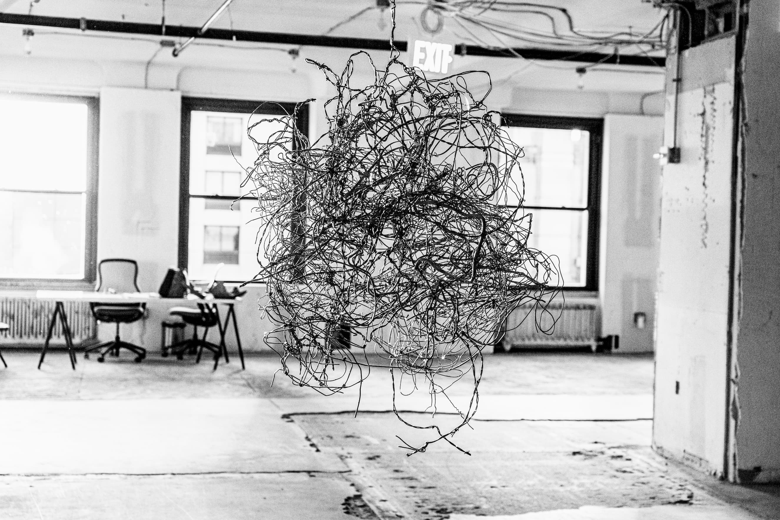 A hanging sculpture resembling a tange of rusting wire